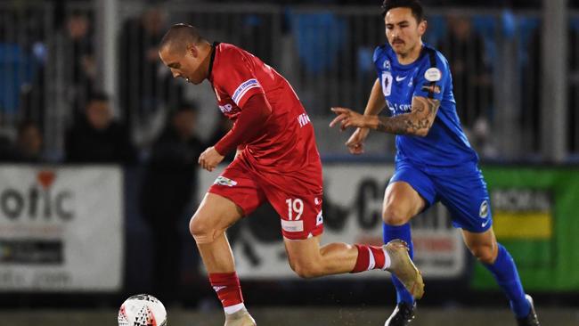 Marko Delic on his way to scoring a hat-trick for Hume City, ahead of Adelaide Olympic’s Matthew Halliday of Olympic. Picture: Mark Brake/Getty Images