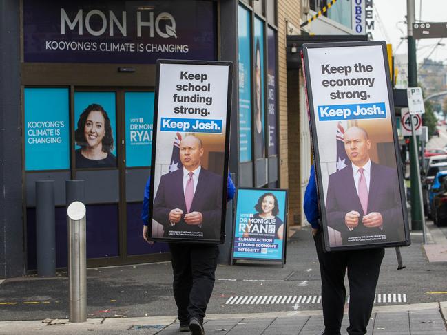 13/05/22 Volunteers wearing Josh Frydenberg billboards walk past the HQ of independent Monique Ryan. Aaron Francis / Herald Sun