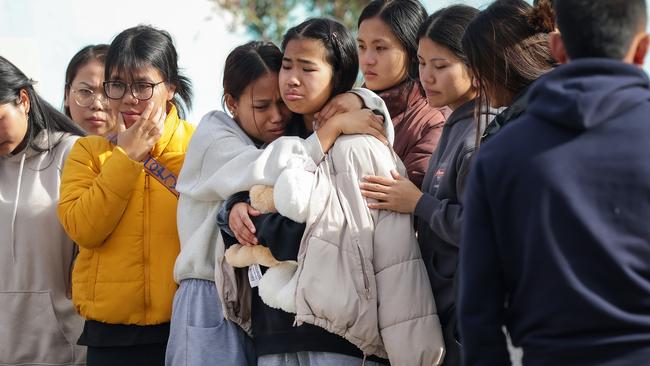 Mourners gather at the bus stop in Sunshine where 16yr old Pa Sawm Lyhym was stabbed to death by youths during the week. Picture: Ian Currie