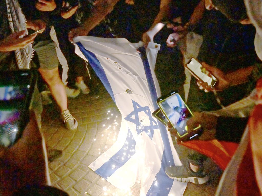 SYDNEY, AUSTRALIA - NewsWire Photos OCTOBER 9, 2023: ÃRally For A Free PalestineÃ protest burn the Israeli flag on the forecourt of The Sydney Opera House in Sydney following the recent outbreak of war between Israel and Palestine. Picture: NCA NewsWire / Jeremy Piper