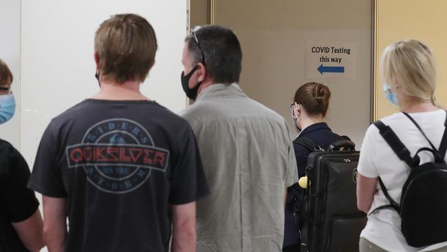 People line up to be COVID tested at Melbourne Airport following their flights from Brisbane. Picture: David Crosling