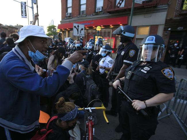 A man talks to a police officer as activists hold a rally over the death of George Floyd in the Brooklyn borough of New York City.