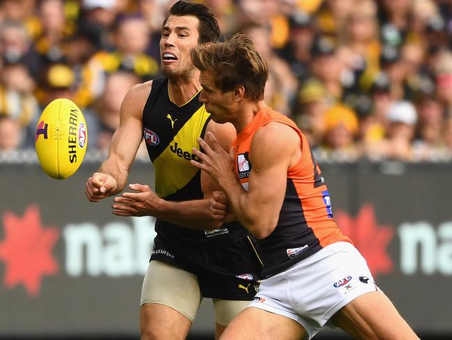 Alex Rance of the Tigers handballs while being tackled by Matt De Boer of the Giants. Picture: Quinn Rooney/Getty Images