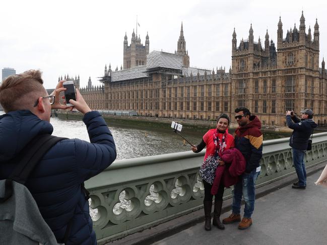 People take selfie photographs of themselves on Westminster Bridge in front of the Houses of Parliament in central London on March 23, 2017 after the bridge reopened to traffic following its closure during the March 22 terror attack. Picture: AFP