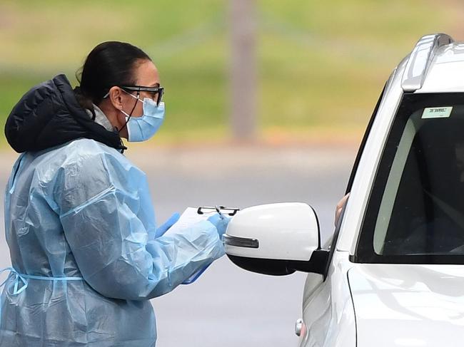 Medical staff prepare to take a swab at a drive-through testing clinic in Melbourne on August 13, 2020. - Australia's virus-hit Victoria state reported a major drop in new coronavirus cases on August 13, but officials warned against complacency amid a "worrying" spread of the disease in regional areas outside Melbourne. (Photo by William WEST / AFP)