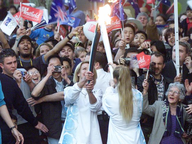 Stephenson lights Maree Holland’s torch at Parramatta during 2000 Olympic Torch Relay.