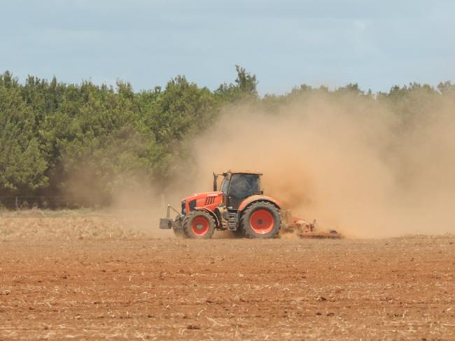 Farming dust. A tractor leaves a trail of dust on a Bundaberg farm.