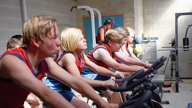 Students involved in the Australian Rules Football Academy at Charles Campbell College train inside one of the school’s fitness rooms. Picture: Phil Heaton