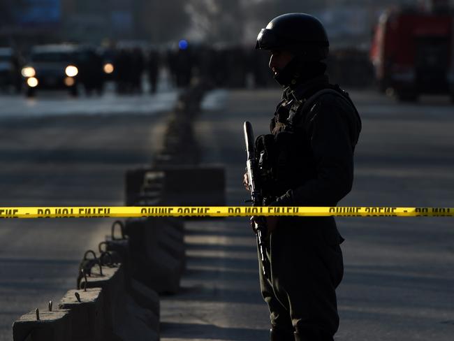 An Afghan security personnel stands guard near the site of a suicide attack at the entrance to a police base in Kabul on February 1, 2016. A Taliban suicide bomber struck a police base in central Kabul on February1, killing at least nine people just days before a fresh round of international talks aimed at reviving dialogue with the Islamist group. AFP PHOTO / WAKIL KOHSAR