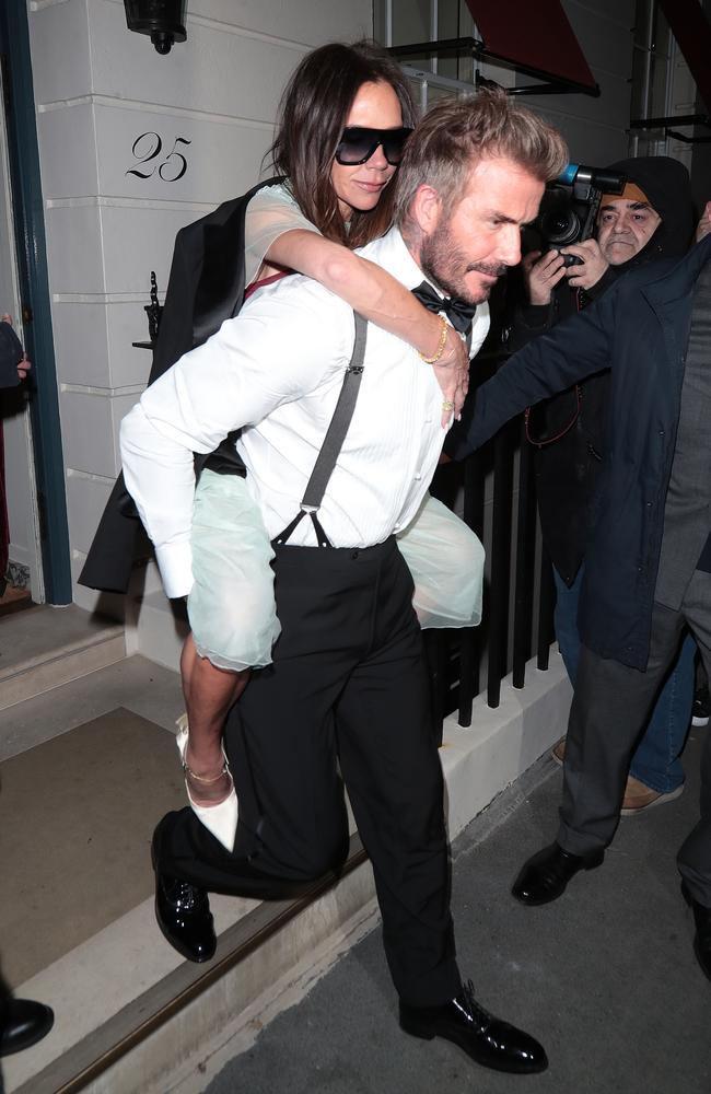 David Beckham gives Victoria Beckham a piggy back as the couple leaves her 50th birthday party at Oswald’s in London. Picture: Ricky Vigil M/Justin E Palmer/GC Images