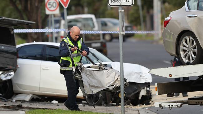 Police retrieve a piece of debris at the scene. Picture: David Crosling