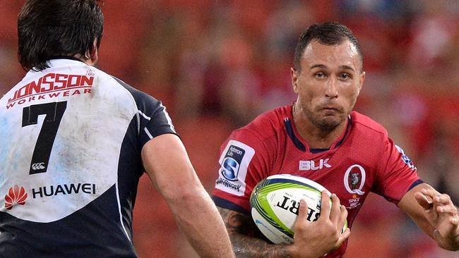 Quade Cooper of the Reds looks to take on the Lions defence.