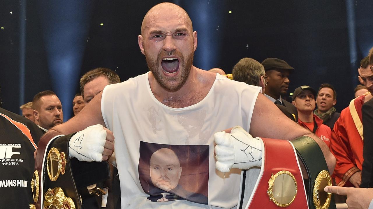 FOR USE AS DESIRED, YEAR END PHOTOS - FILE - Britain's new world boxing champion Tyson Fury celebrates with the WBA, IBF, WBO and IBO belts after winning the world heavyweight title fight against Ukraine's Wladimir Klitschko in the Esprit Arena in Duesseldorf, western Germany, Sunday, Nov. 29, 2015. (AP Photo/Martin Meissner, File)