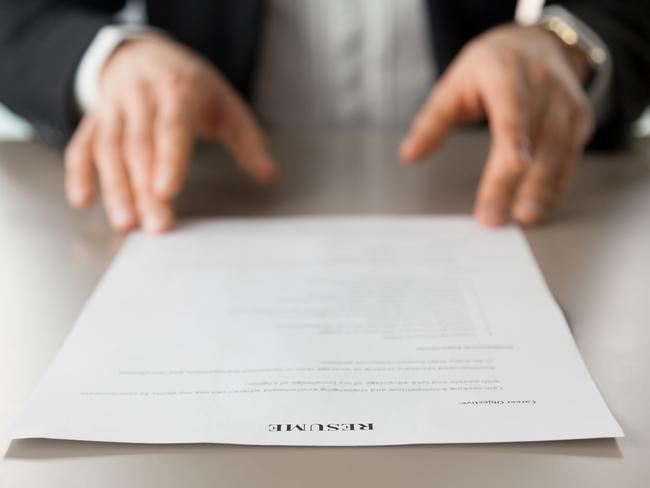 Resume document with guys hands in background. Recruitment manager reads resume. Job applicant offers CV to recruiter at interview. Employer examines achievements of new company worker. Close up photo