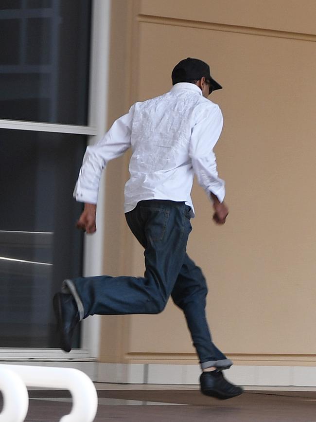 Mohammad Qadir runs from the Supreme Court after the second day of his trial