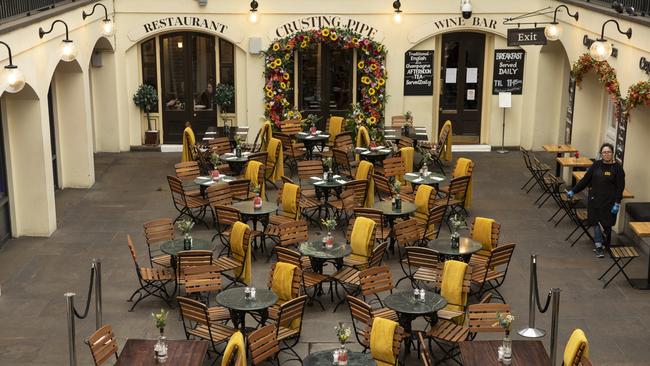 An employee waits over empty tables in London’s Covent Garden on Tuesday. Picture: Getty Images