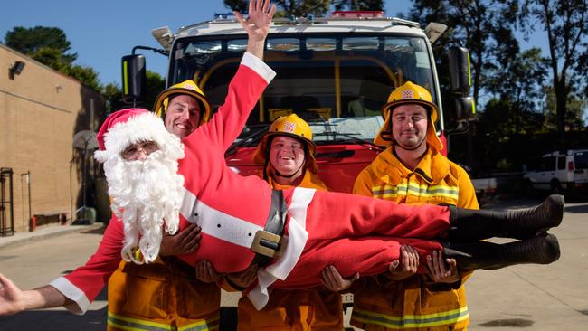 Santa with Ferntree Gully CFA volunteers, Andrew Stanley, Scott Monssen and Dylan Davies. Picture: Christopher Chan.