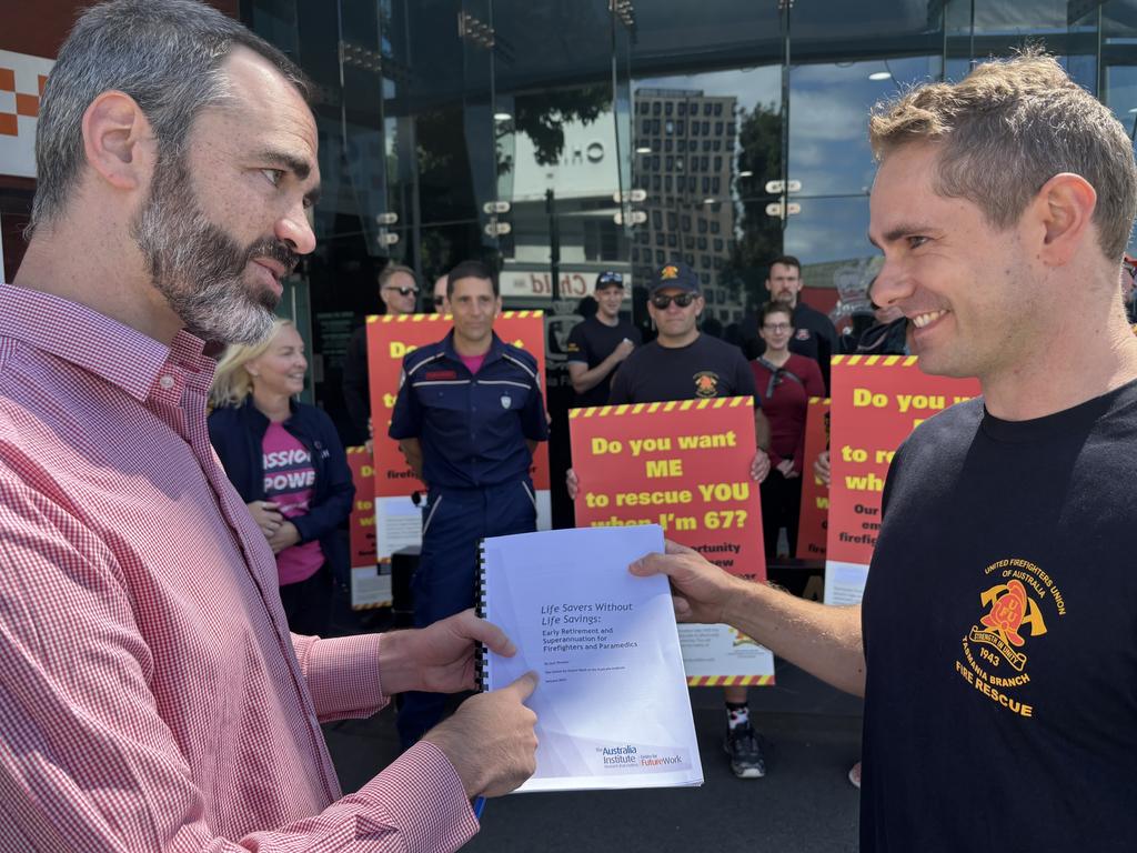 United Firefighters Union of Australia Tasmania Branch Industrial Organiser Stephen McCallum and Workplace Representative Toby Bresnehan looking at the latest report by the Australia Institute’s Centre for Future Work. Picture: Simon McGuire.