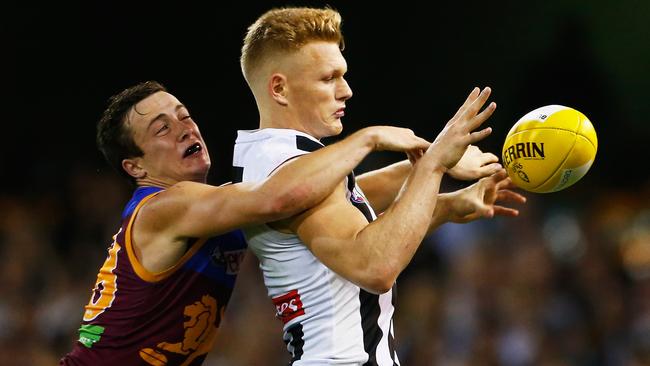 Adam Treloar tries to gather under pressure from Lewis Taylor.