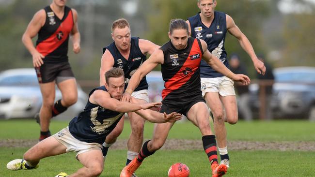 Edithvale-Aspendale’s Sam Monaghan lunges for the ball in front of Frankston Bombers player Dale Sutton. Picture: Chris Eastman