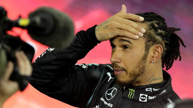 Second-placed Mercedes' British driver Lewis Hamilton reacts in the parc ferme of the Yas Marina Circuit after the Abu Dhabi Formula One Grand Prix on December 12, 2021. – Max Verstappen became the first Dutchman ever to win the Formula One world championship title when he won a dramatic season-ending Abu Dhabi Grand Prix at the Yas Marina circuit on December 12, 2021. The Red Bull driver won his 10th race of the season to finish ahead of seven-time champion Lewis Hamilton. (Photo by KAMRAN JEBREILI / POOL / AFP)