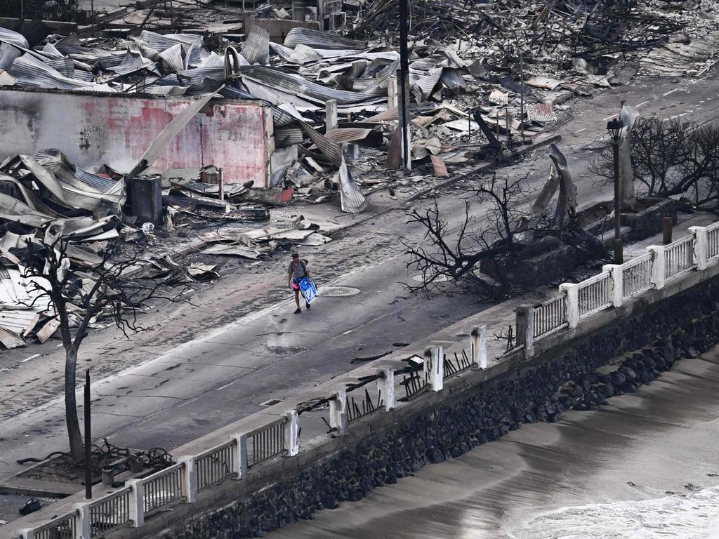 A person walking down Front Street past destroyed buildings burned to the ground in Lahaina in western Maui, Hawaii. Picture: AFP