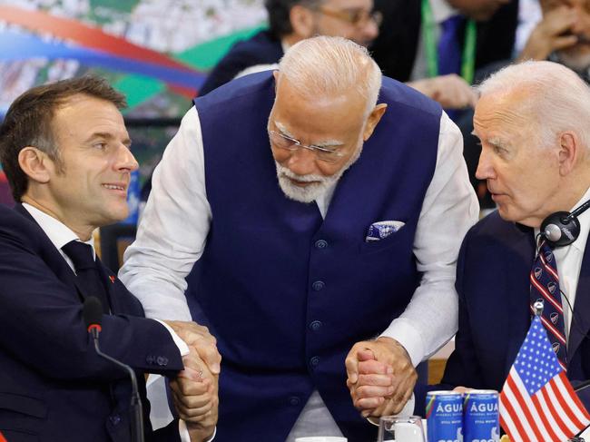 (L to R) France's President Emmanuel Macron, India's Prime Minister Narendra Modi, and US' President Joe Biden hold hands during the third session of the G20 Leaders' Meeting in Rio de Janeiro, Brazil, on November 19, 2024. (Photo by Ludovic MARIN / AFP)