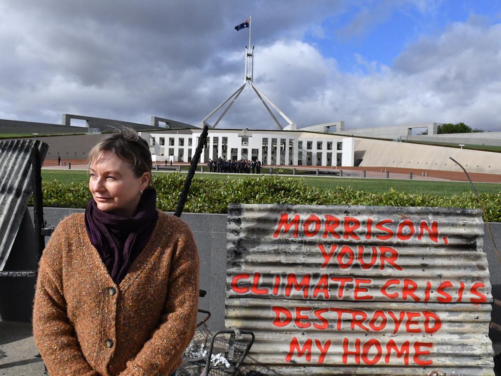 Melinda Plesman stands with the remains of her burnt out house, outside Parliament House in Canberra. Picture: Mick Tsikas/AAP