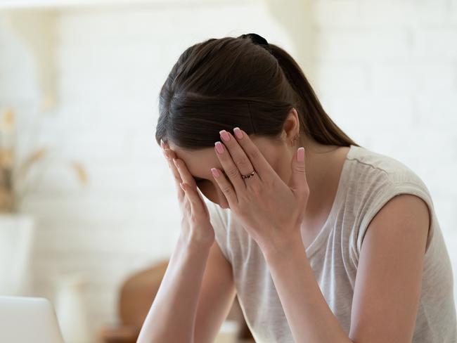 Upset woman touching head using calculator and laptop for calculating finance. Frustration young housewife with headache taxing, accounting, statistics Mortgage home loan money stress generic