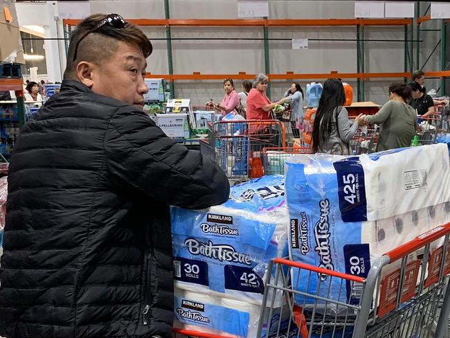 A man prepares to buy 150 rolls of toilet paper at a store, as people begin to panic buy and stockpile essentials from fear that supplies will be affected by the spread of the COVID-19, coronavirus outbreak across the country, in Los Angeles, California on February 29, 2020. - The US has suffered its first virus related death as the number of novel coronavirus cases in the world rose to 85,919, including 2,941 deaths, across 61 countries and territories. (Photo by Mark RALSTON / AFP)