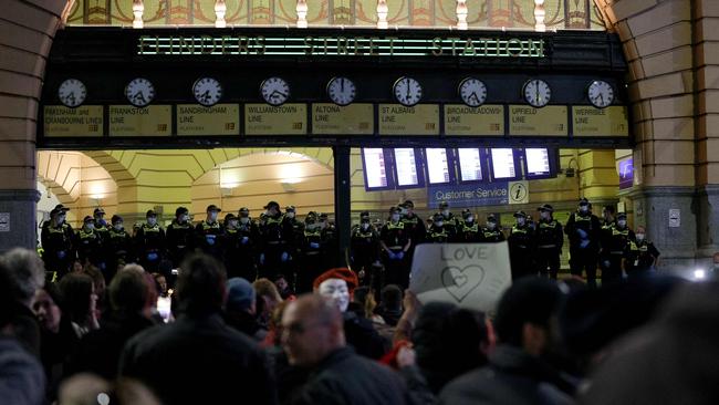 Police watched on as crowds gathered at Flinders Street Station. Picture: AFP