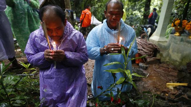 Relatives of the trapped boys pray for their rescue. Picture: AP.