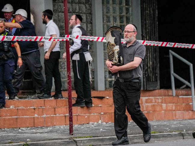 MELBOURNE, AUSTRALIA - DECEMBER 06: A member of the Jewish community recovers an item from the Adass Israel Synagogue on December 06, 2024 in Melbourne, Australia. An arson attack on the Adass Israel Synagogue in Melbourne forced congregants to flee as flames engulfed the building early on Friday morning. Prime Minister Anthony Albanese condemned the incident as an antisemitic act, emphasizing that such violence at a place of worship is unacceptable in Australia. (Photo by Asanka Ratnayake/Getty Images)