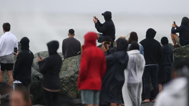 Spectators watch on as surfers hit the waves at Coolangatta. Picture: Jason O'Brien