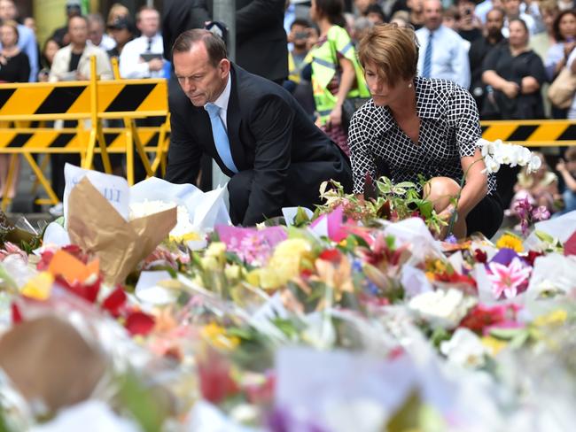 Australian Prime Minister Tony Abbott and his wife Margaret pay their respects at a makeshift memorial in Martin Place. AFP PHOTO/Peter PARKS