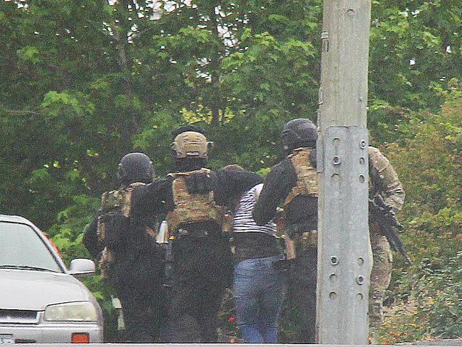 Brett Julian Robinson-Stacey is lead away after being arrested after officers stormed the house to end the 16-hour siege. Picture: BRUCE MOUNSTER