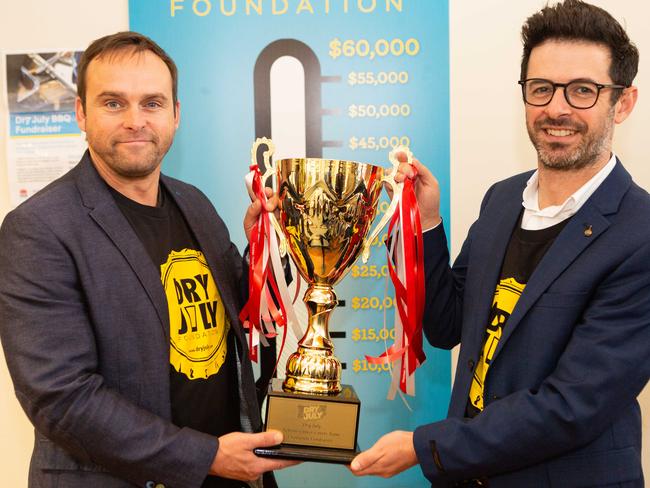 Actor Les Hill and Dr Deme Karikios hold up the fundraising champion trophy. Picture: Jordan Shields