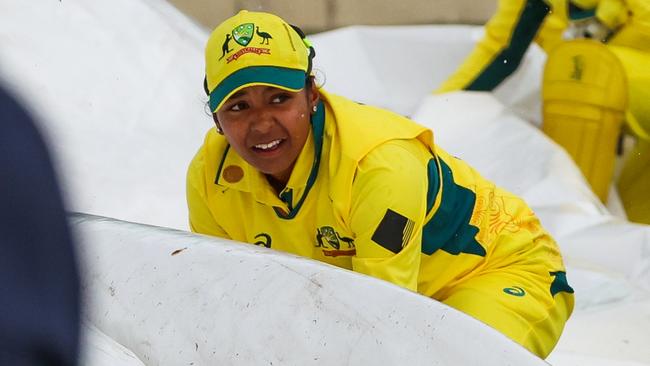 MELBOURNE, AUSTRALIA - OCTOBER 12: Australian players assist ground staff in carrying the pitch covers as the rain comes in during game two of the womens One Day International series between Australia and the West Indies at Junction Oval on October 12, 2023 in Melbourne, Australia. (Photo by Asanka Ratnayake/Getty Images)