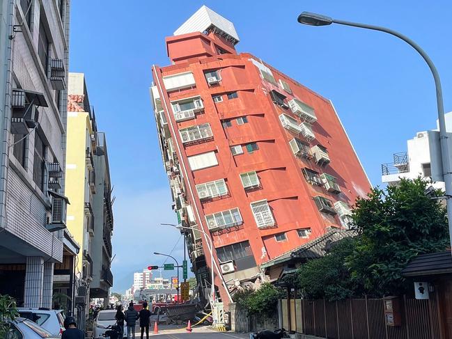 TOPSHOT - This photo taken by Taiwan's Central News Agency (CNA) on April 3, 2024 shows people looking at a damaged building in Hualien, after a major earthquake hit Taiwan's east. A major 7.4-magnitude earthquake hit Taiwan's east on the morning of April 3, prompting tsunami warnings for the self-ruled island as well as parts of southern Japan and the Philippines. (Photo by CNA / AFP) / China OUT - Macau OUT - Taiwan OUT / HONG KONG OUT - RESTRICTED TO EDITORIAL USE