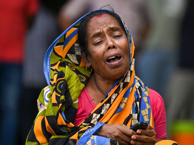 A victim's family member weeps at a business park used as temporary mortuary to identify the dead recovered from the carriage wreckage of a three-train collision. Picture: AFP