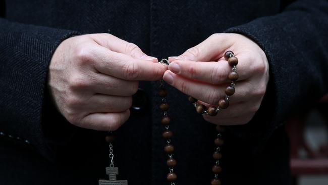 A supporter of the church is seen with his rosary beads.