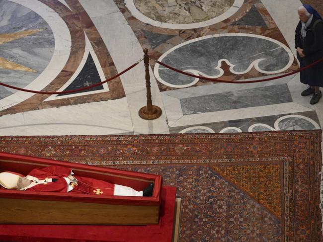 Sister Genevieve Jeanningros prays in front of the body of late Pope Francis inside St. Peter's Basilica at the Vatican, Wednesday, April 23, 2025, where he will lie in state for three days. (Alessandro Di Meo/ Pool Photo via AP)