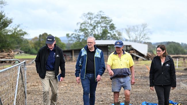 Australian Prime Minister Anthony Albanese with dairy farmer Milton Johnson (centre right) on his property during a visit to the flood effected region of Taree. Picture: Dean Lewins
