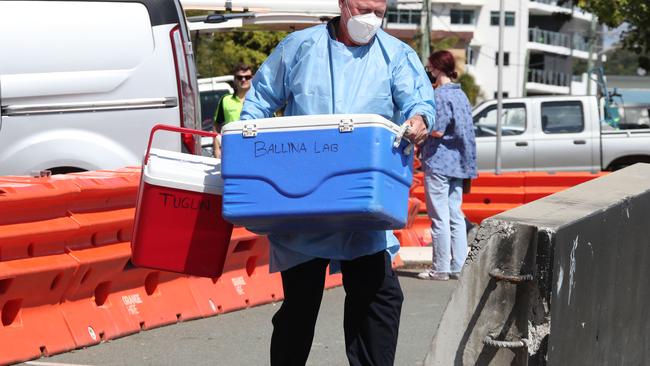 Scenes from the Qld/NSW border wall in Dixon St Coolangatta/Tweed. QML Labs are forced to exchange samples over the wall. Picture Glenn Hampson