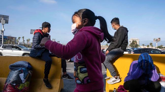 Young would-be migrants or asylum seekers at the weekend after spending the night in one of the car lanes off the San Ysidro Crossing Port on the Mexican side of the US border in Tijuana. Picture: AFP