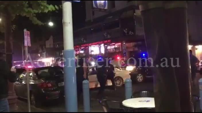 Police and STAR force personnel surround a car in Hindley St