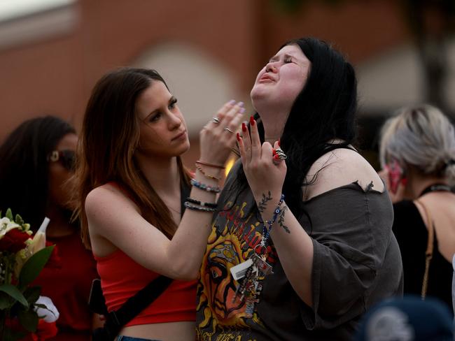 Brooklyn Deese (L) comforts Alexa Keith as they visit a memorial next to the Allen Premium Outlets on May 7, 2023 in Allen, Texas. Picture: Getty Images via AFP