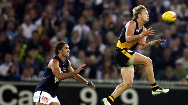 Kayne Pettifer playing for Richmond against Carlton in AFL football – Richmond vs. Carlton match at the MCG. Footballer Kayne Pettifer takes the mark in front of Andrew Walker.