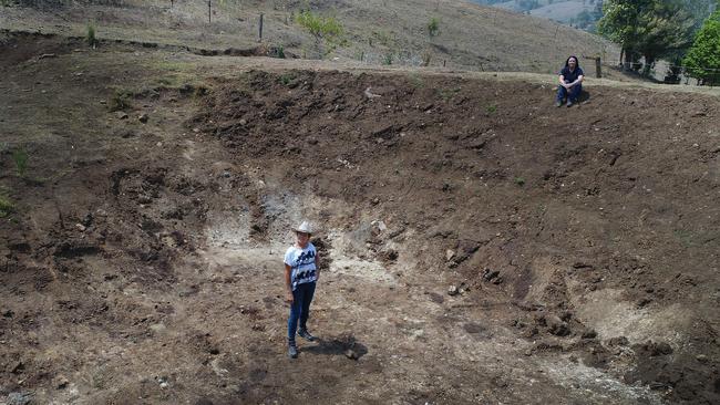 Emily Spurr and Julie Tetlow stand in an empty dam at their property. Picture: Glenn Hampson.