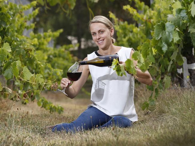 Renee Mc Bride of Werribee's Shadowfax Wines pours a glass of their finest while families relax on picnic rugs on the grass. Picture: David Caird